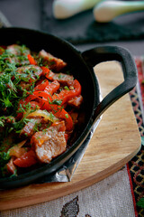 Deliciously Cooked Meats and Vegetables in a Cast Iron Skillet with a Touch of Fresh Herbs, Showcasing a Colorful Culinary Delight