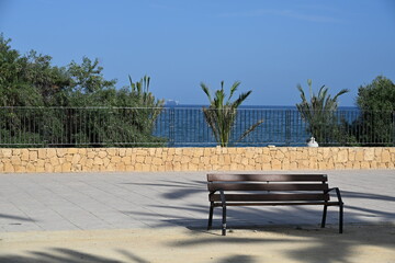 ławka a w tle palmy i morze