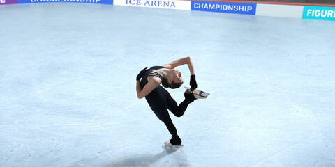 Figure skater girl skating on ice stadium.