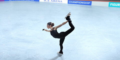 Figure skater girl skating on ice stadium.