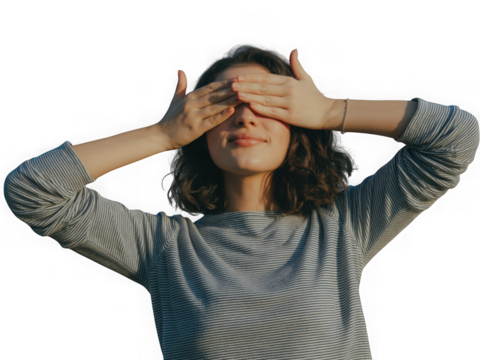 Young woman covering eyes with hands against black background