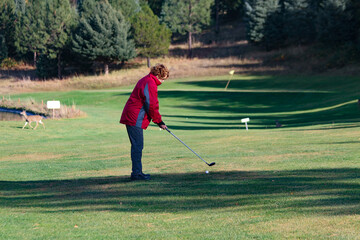 photo of senior woman playing golf on rural golf course at Kayler's Bend along the Southfork River in Idaho