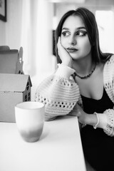 Portrait of a young beautiful long-haired girl in a cafe.