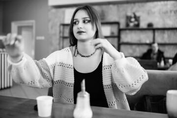 Portrait of a young beautiful long-haired girl in a cafe.