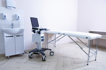 Modern ultrasound machine, sink and examination bed in clinic