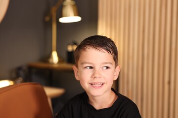Cute little boy with wet hair in barbershop