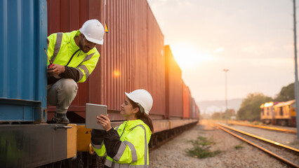 Foreman checking inventory or task details on freight train cars and shipping containers. Logistics concept, import, and export industries.