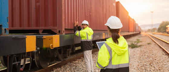 Foreman checking inventory or task details on freight train cars and shipping containers. Logistics concept, import, and export industries.