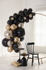 Stylish photo zone with balloons, chair and decor in studio