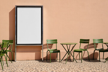 Mockup with blank outdoor poster on peach wall surrounded by green chairs for announcements, educational events, school or course promotions with free copy space for text or public information