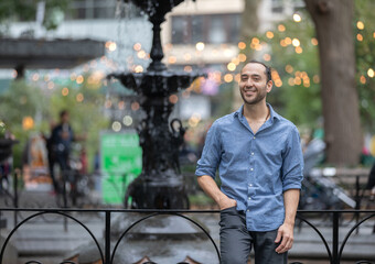 Smiling Hispanic Person in a Manhattan Park with Blurred Background and Bokeh Lights