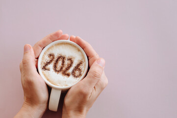 woman enjoying hot coffee. On milk foam numbers 2026. New Year concept