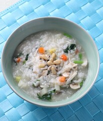 A hearty bowl of Korean farmhouse-style mushroom porridge featuring shiitake, oyster, button, king...