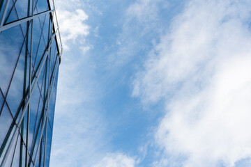 Contemporary glass building facade with geometric metal framework is shown on the left, reflecting...