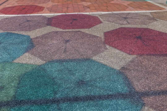 夏の晴れた日に、地面に映る色とりどりの傘の影