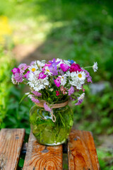 Glass vase with beautiful bouquet of summer wild flowers