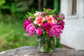 Beautiful bouquet of summer peonies flowers in a glass vase 