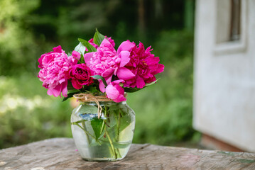 Beautiful bouquet of summer peonies flowers in a glass vase 