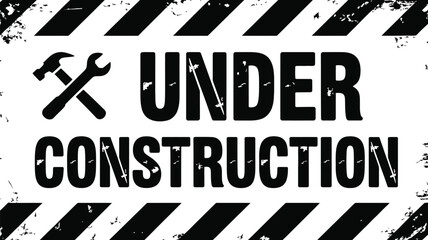 A yellow and black under construction sign warns of hazards and restricted access at an industrial site