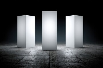 Three blank white rectangular pillars on a dark concrete floor