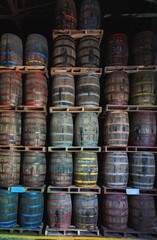 Colorful wooden barrels stacked in a warehouse.