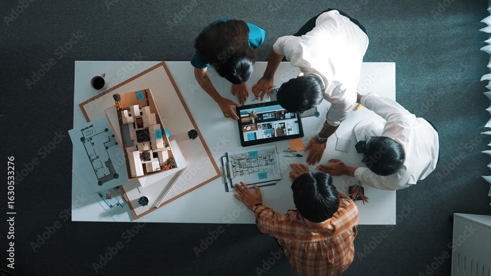 Poster top down view of architect engineer team discussing and point at tablet display construction at tabl