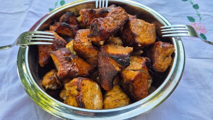 Grilled meat in a metal bowl, top view