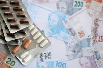 Brazilian reais banknotes and medicine pills. Brazil real money and drugs lies on table