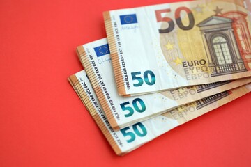 Big amount of european euro currency money notes on red color table close up