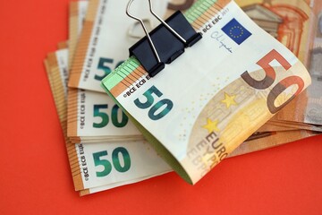 Big amount of european euro currency money notes on red color table close up
