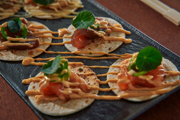 Delicious Gourmet Appetizers Featuring Creative Tortilla Bites Topped with Fresh Ingredients, Sauces, and Vibrant Microgreens for a Unique Culinary Experience
