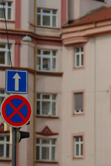 Located in front of a specific building, there is a prominently displayed no parking sign that...