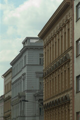 A picturesque row of buildings lining a bustling city street, set against a clear blue sky that enhances the urban landscapes beauty