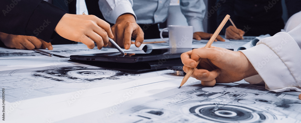 Aufkleber hands engaged in a discussion over graphical design plans and technical drawings during a collaborat