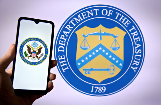 The U.S. Department of State logo on a cell phone screen with the seal of the U.S. Department of Treasury in the background. Rio de Janeiro, Brazil: August 5, 2025.