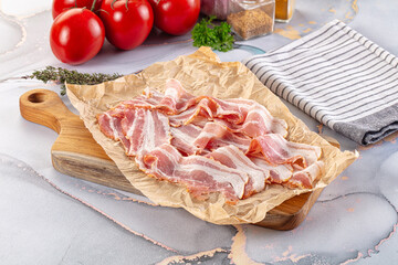 Sliced pork bacon over board