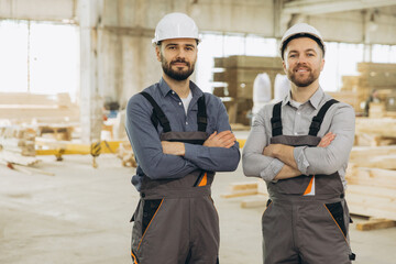 Construction workers posing with arms crossed in modular building factory