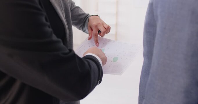 Business meeting for discussion of urban construction project by expert and investors. Architect holding paper land map to discuss and talk, showing paper document to explain and plan blueprint