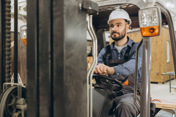 Warehouse worker driving forklift in modular building industry