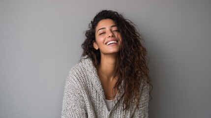 portrait of happy latin young woman isolated on grey wall with copy space carefree hispanic woman smiling and looking at camera standing on gray background beautiful multiethnic girl laughing no logo