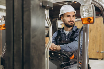 Factory worker driving forklift in modular building industry