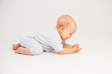 a baby crawling on a white isolated background, a small boy learning to crawl, space and room for...