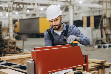 Carpenter working with woodworking machine producing modular building components