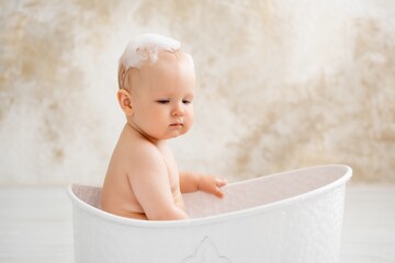 baby in the bathtub, boy bathing or washing in a bathtub with bath foam, baby's hygiene.