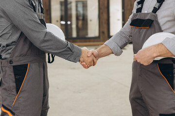 Construction workers shaking hands at modular building site