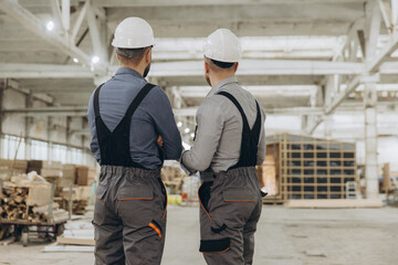 Engineers inspecting prefabricated building in factory