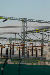 A large collection of various electrical wires is suspended from a sturdy metal structure, possibly...