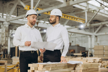 Engineers discussing plans in modular building construction factory