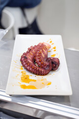 emplatado de patas de pulpo cocidas con salsa y pimentón
