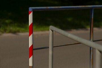 A striking red and white striped pole is placed on a sturdy metal railing, adding a colorful touch...